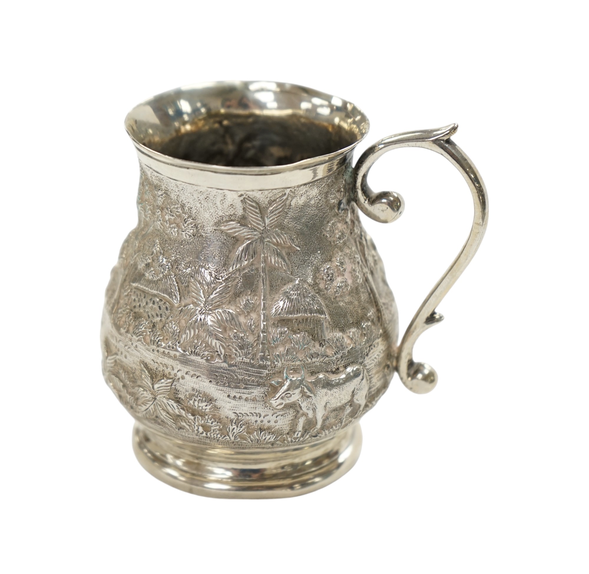 An Indian embossed white metal baluster mug, height 77mm, 94 grams. Condition - poor to fair